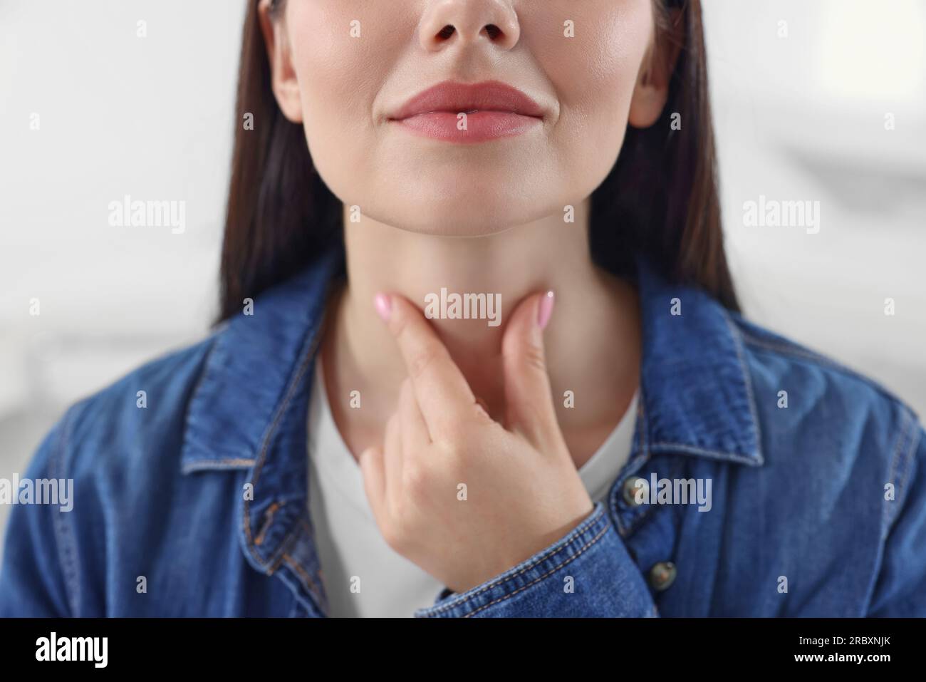 Endocrine system. Woman doing thyroid self examination indoors, closeup Stock Photo