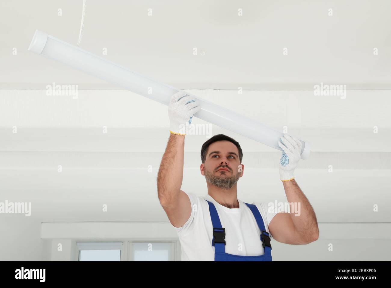 Electrician installing led linear lamp indoors. Ceiling light Stock ...