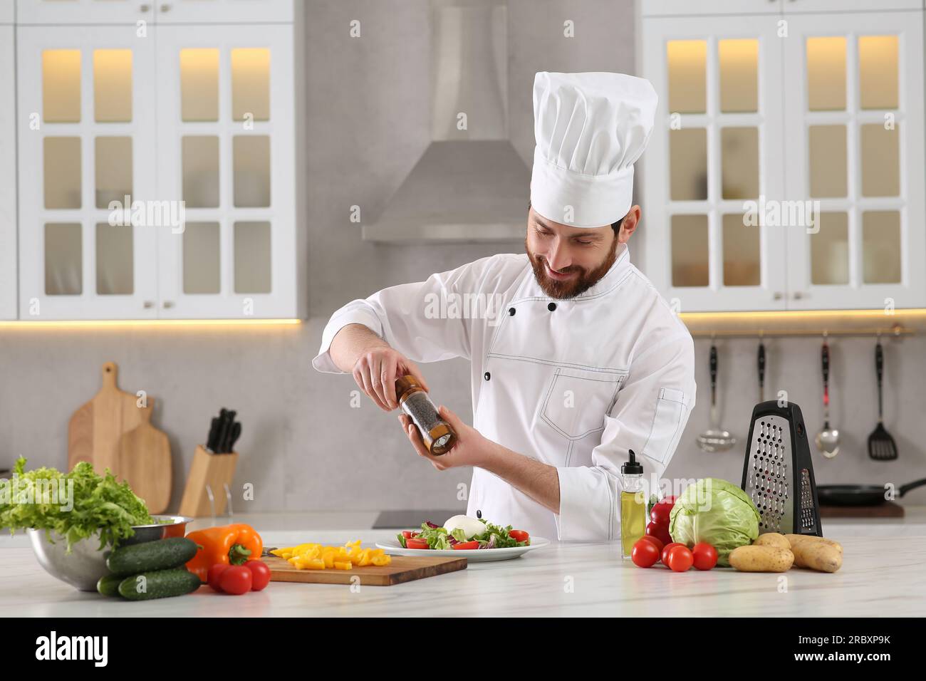 Chef Add Topping Professional chef adding pepper into delicious salad at marble table in ...