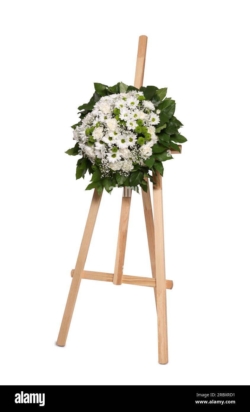 Funeral wreath of flowers on wooden stand against white background Stock Photo