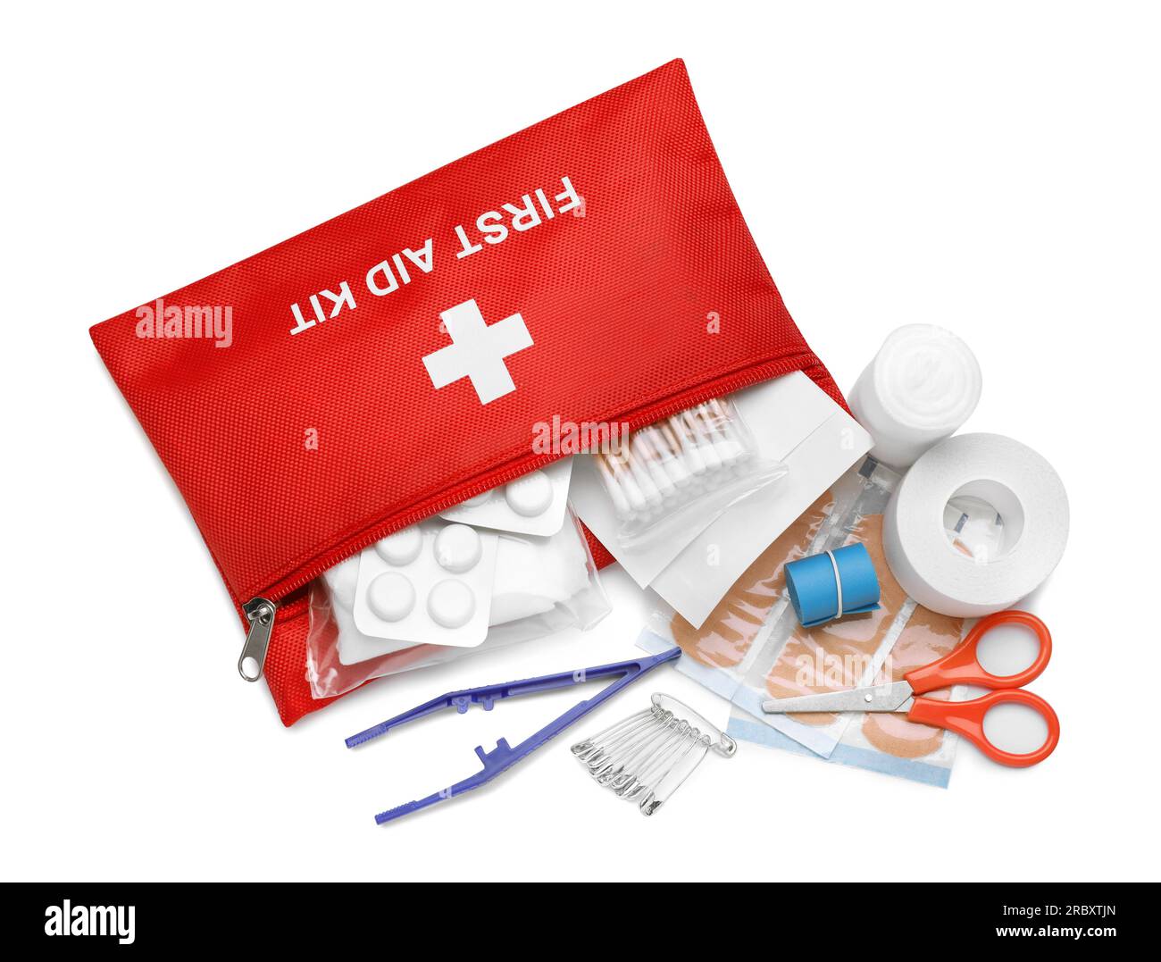 Red first aid kit with scissors, pins, cotton buds, pills, plastic