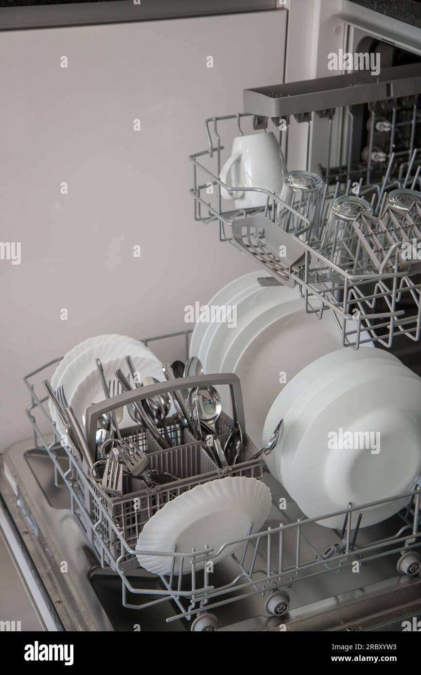 Dishwasher open and ready to remove washed dishes. Concept of saving