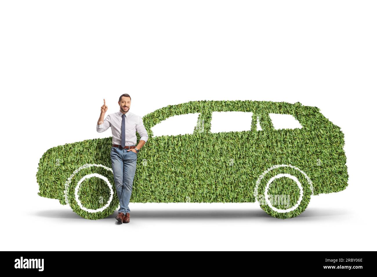 Full length portrait of a man leaning on a green car made of grass and pointing up isolated on white background Stock Photo