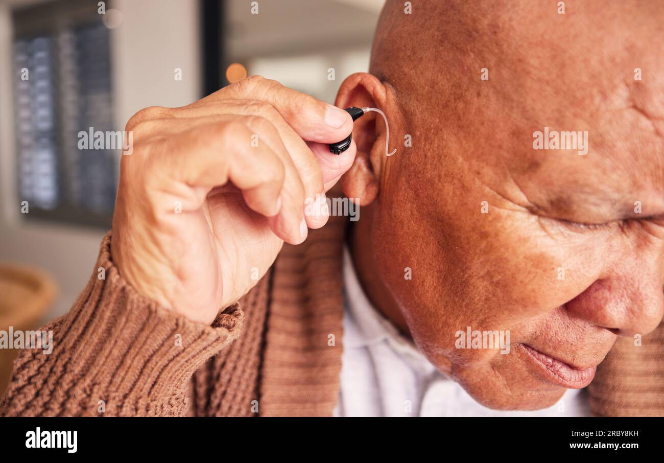 Hearing aid, ear and a senior man with a disability in his home closeup ...
