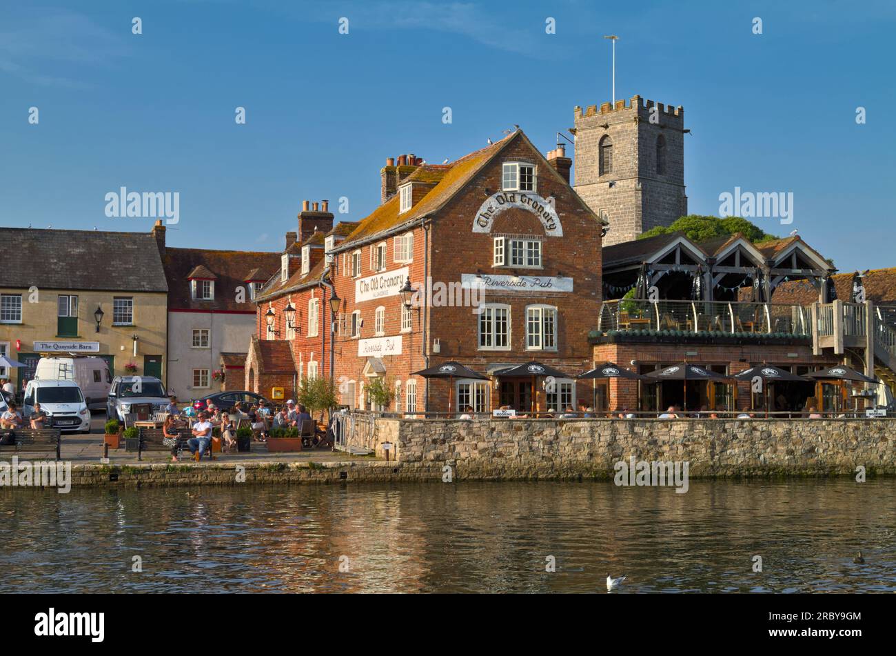 Houses, Restaurants, Lady Saint Mary Church And Old Granary Public House On The Quay Alongside The River Frome, Wareham, Dorset UK Stock Photo