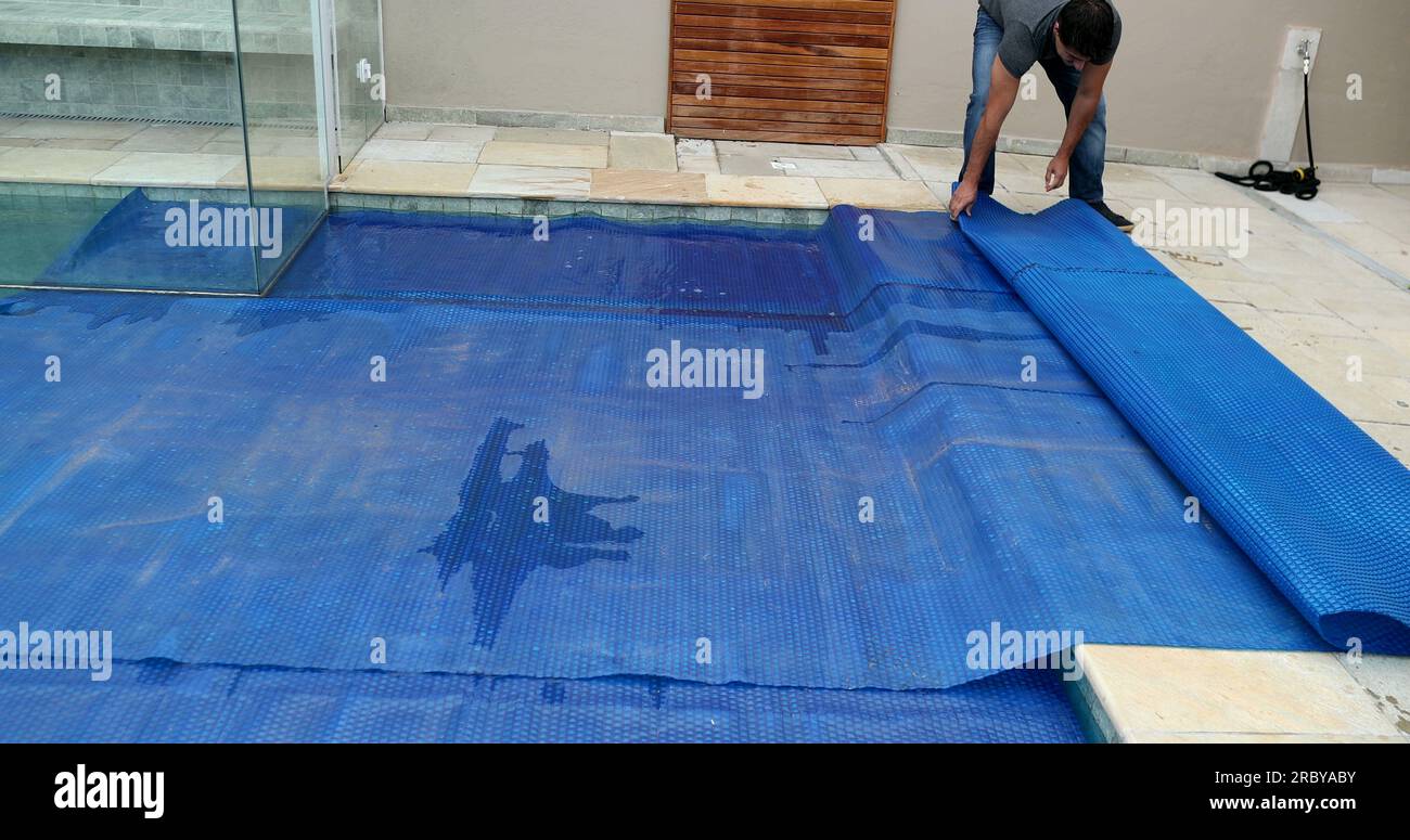 People removing swimming pool cover Stock Photo Alamy