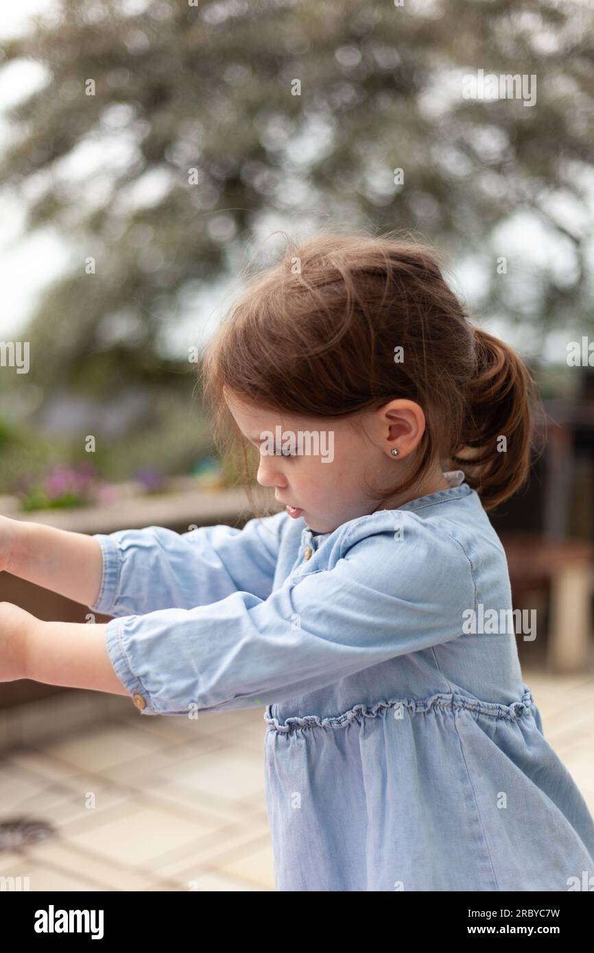 Portrait of a cute little girl in a blue dress, outdoors Stock Photo ...