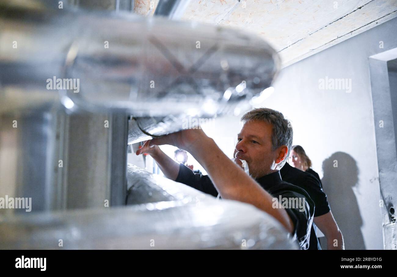 Cologne, Germany. 11th July, 2023. During his summer trip, Robert Habeck (Bündnis 90/Die Grünen), Federal Minister for Economics and Climate Protection, is shown insulating pipes in a heating cellar at the Temperaturwerk für Heiztechnik craftsman's workshop, where he lends a hand. Credit: Bernd Weißbrod/dpa/Alamy Live News Stock Photo