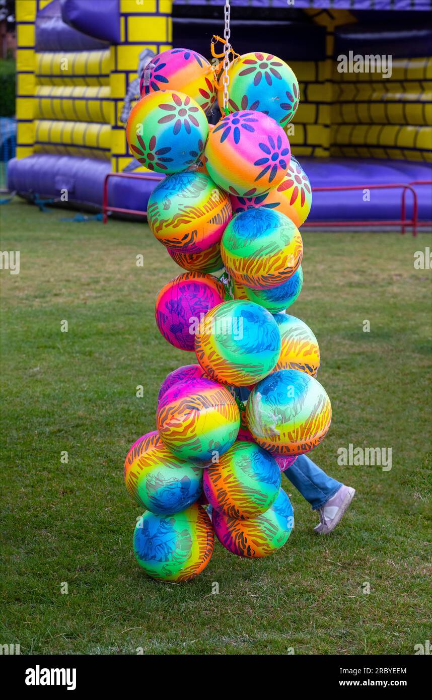Group of colourful inflatable balls in front of a bouncy castle, summer