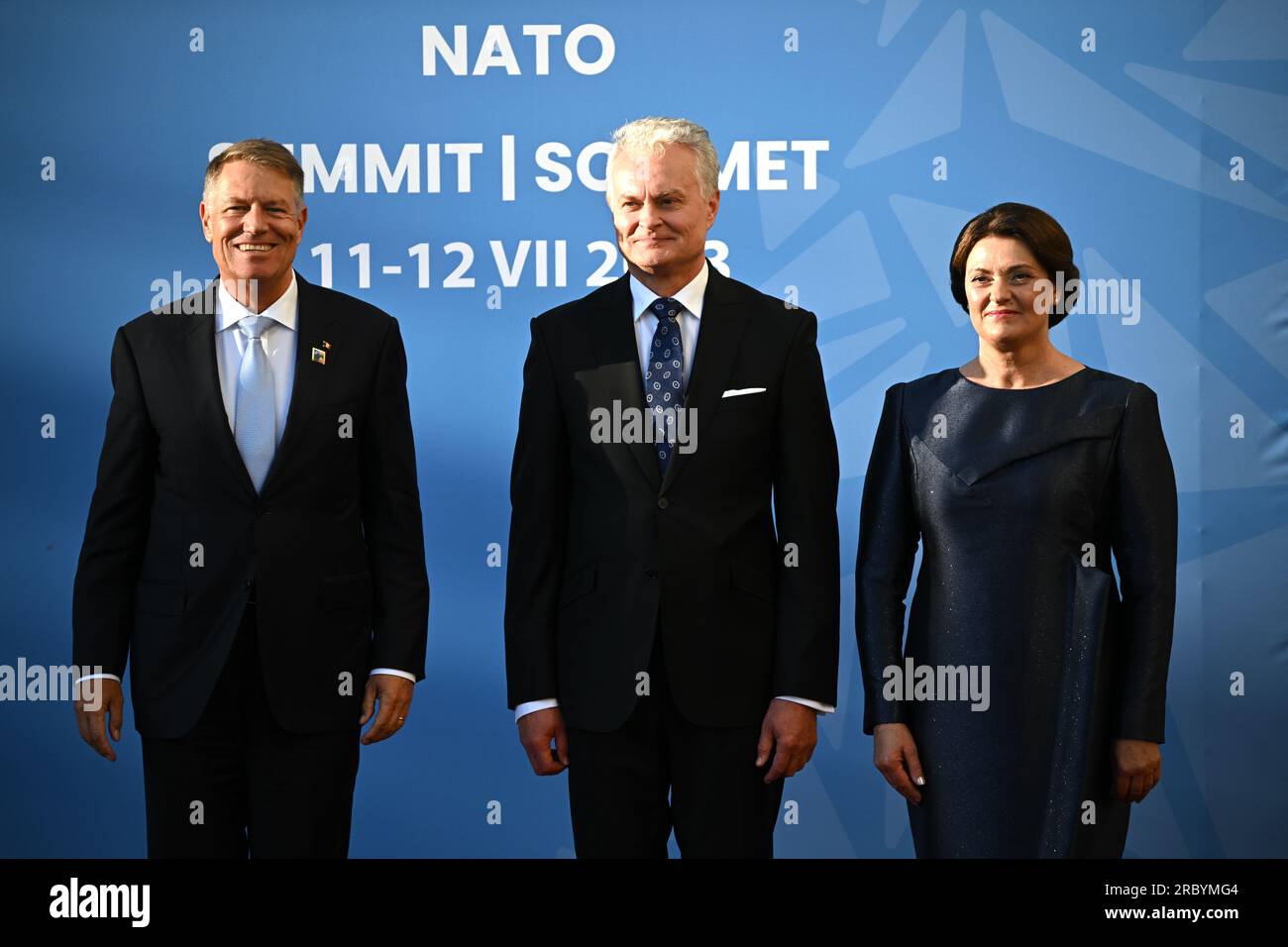 Romania's President Klaus Johannis (left), is greeted by Lithuania's President Gitanas Nauseda and his wife Diana Nausediene for the social dinner during the Nato summit in Vilnius, Lithuania. Picture date: Tuesday July 11, 2023. Stock Photo