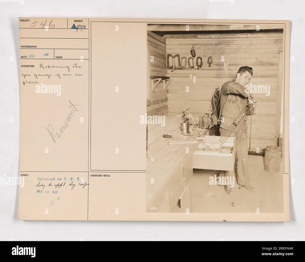 "Servicemen repairing the gas gauge of an airplane during World War One. This image shows the