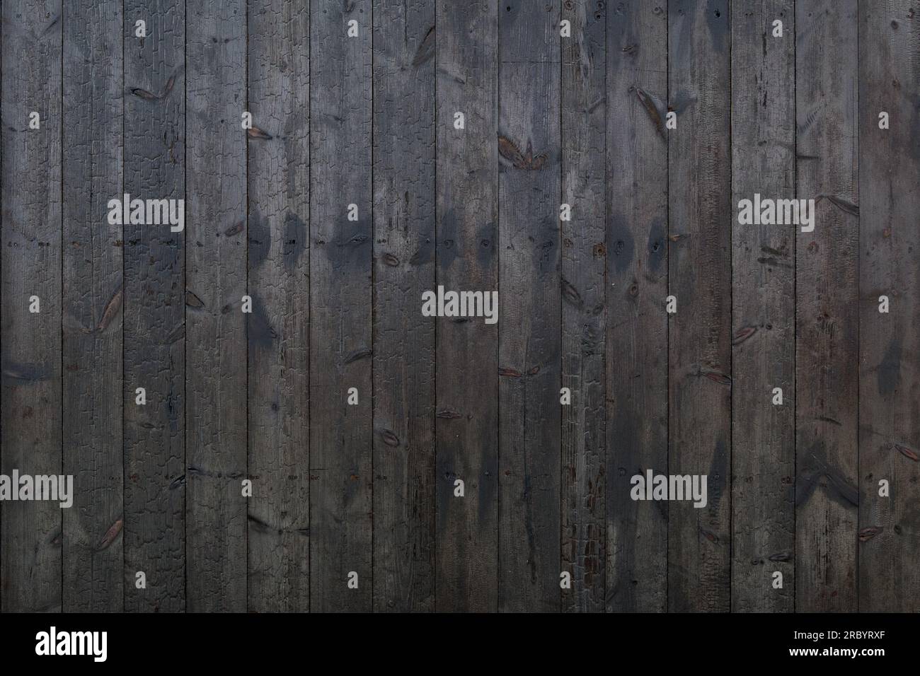 Vertical black dark burned wood vertical linear pattern facade. Stock Photo