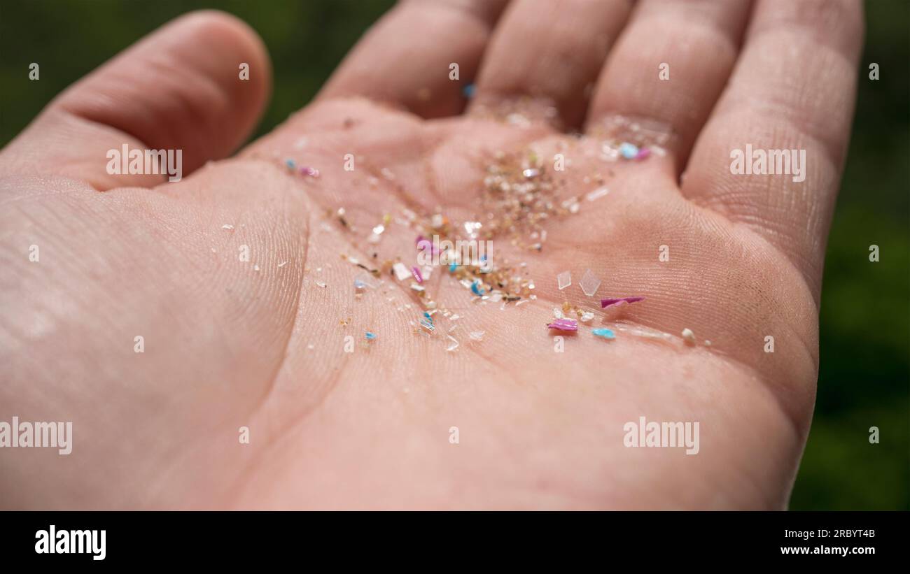 Person holding micro plastic gathered from the ocean in his hand. Concept for plastic pollution and climate change. Stock Photo