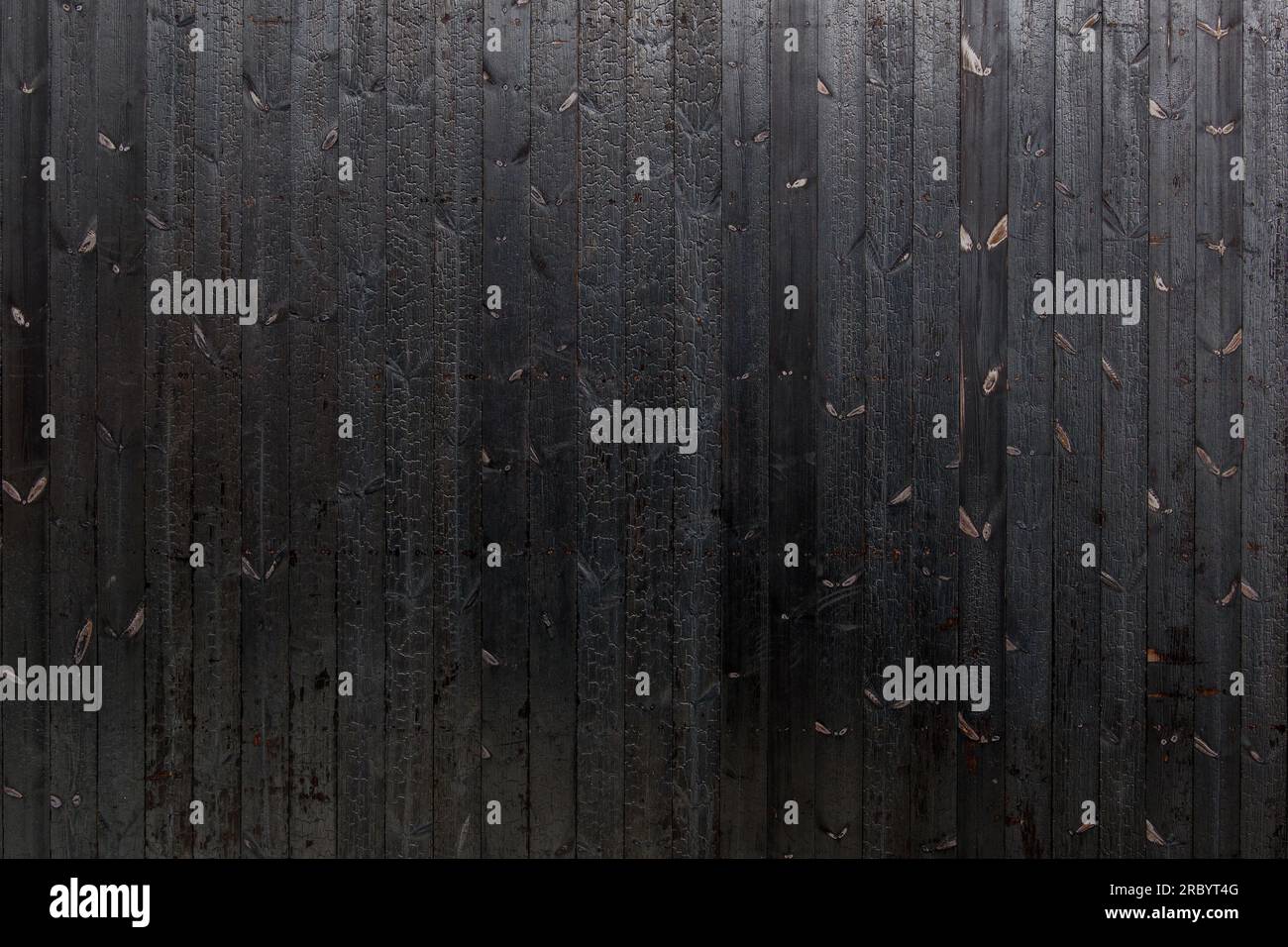 Vertical black dark burned wood vertical linear pattern facade. Stock Photo