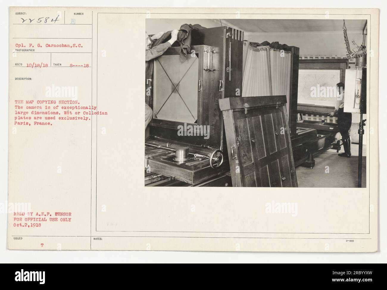 111-SC-22584 is a photograph taken in August 1918, depicting the map copying section during World War One. The camera used for this image is unusually large, and exclusively uses wet or collodian plates. The photo was captured in Paris, France, and is associated with Cpl. P. G. Carnochan of the Signal Corps. It remains in possession of A.E.P. Bensor and is intended for official use only. Stock Photo