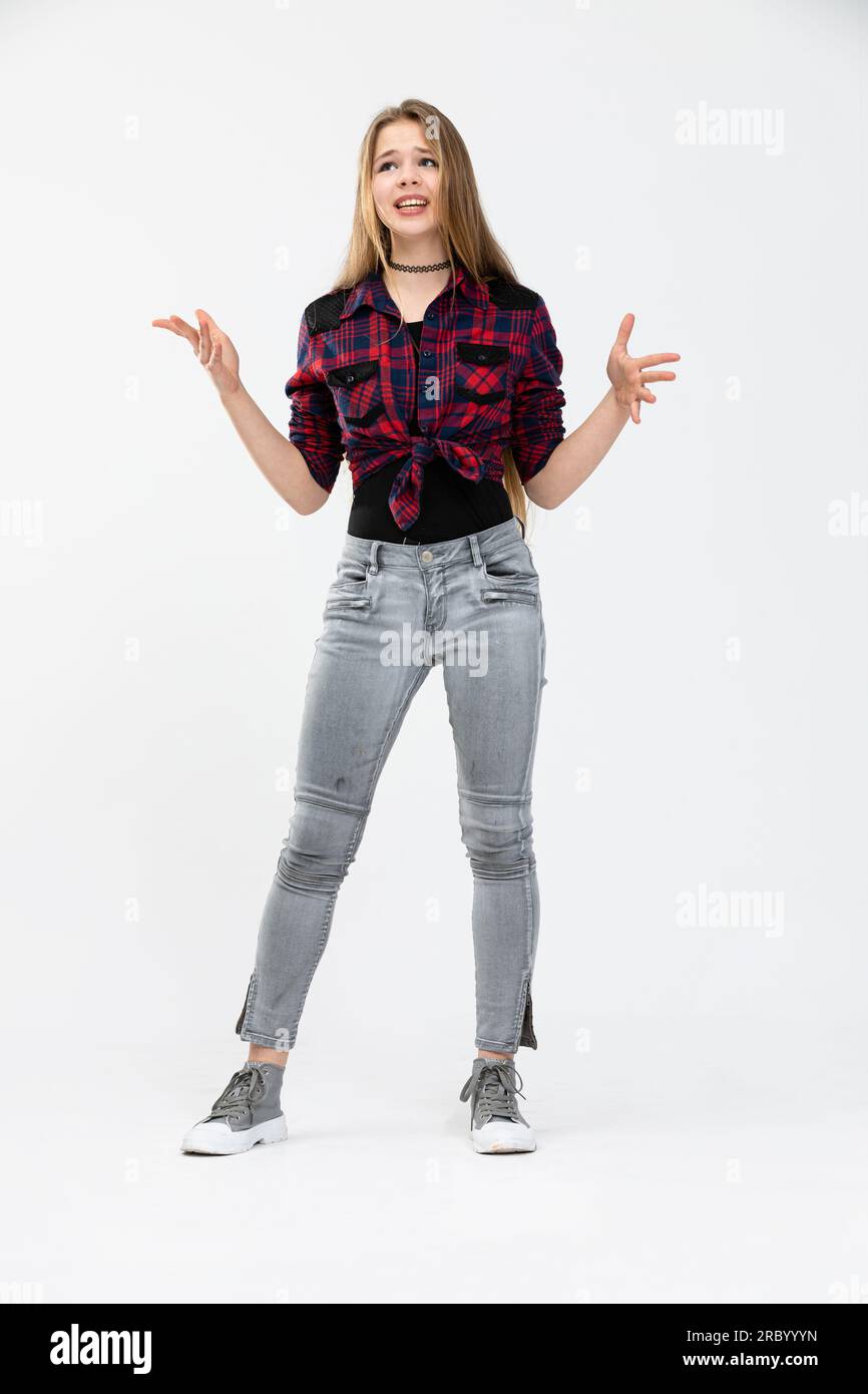 A young person wearing a checked shirt poses against a white background in a standing position. Stock Photo