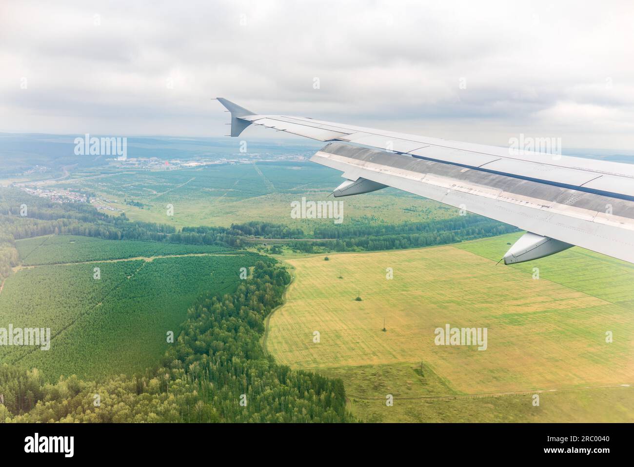 view-of-airplane-wing-blue-skies-and-green-land-during-landing