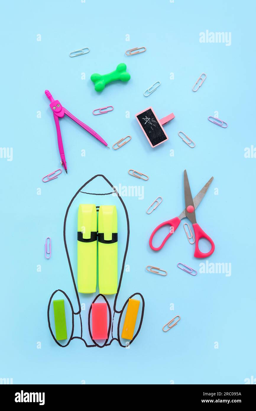 Creative composition with drawn rocket and different stationery on blue background Stock Photo