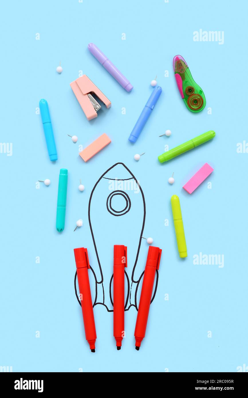 Creative composition with drawn rocket and different stationery on blue background Stock Photo