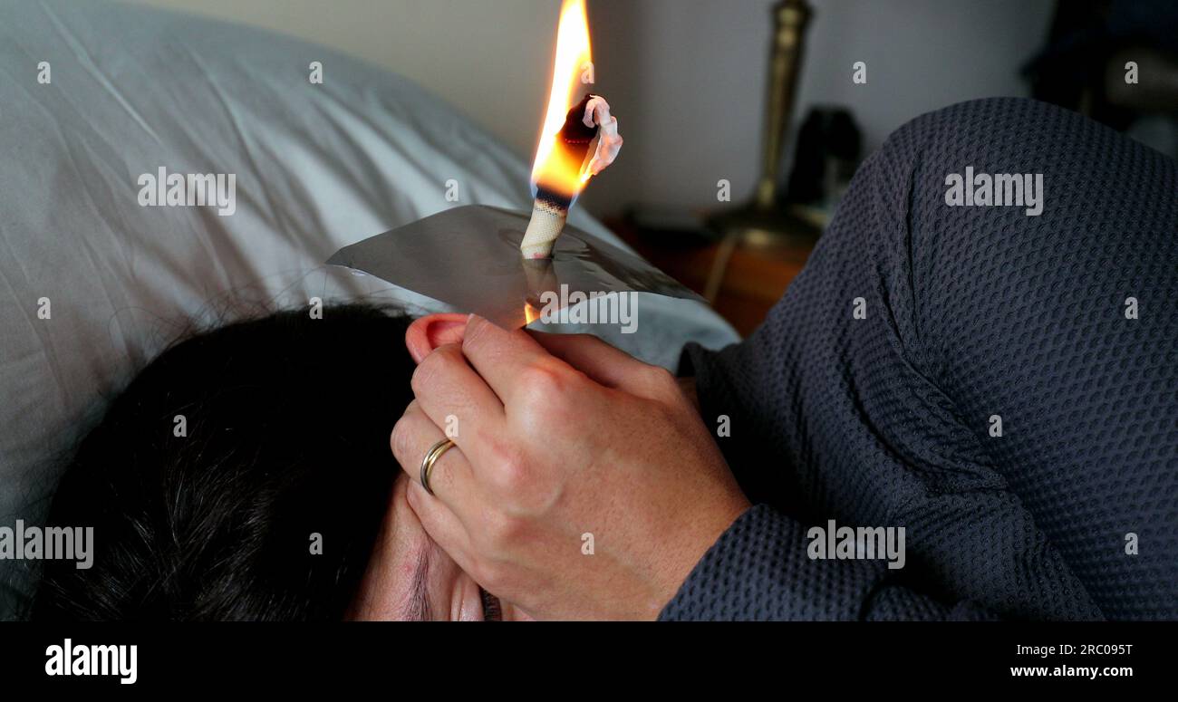Burning cone ear wax removal ear candling Stock Photo Alamy