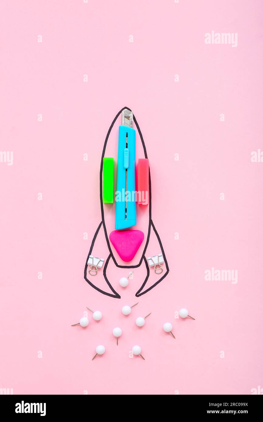 Creative composition with drawn rocket and different stationery on pink background Stock Photo