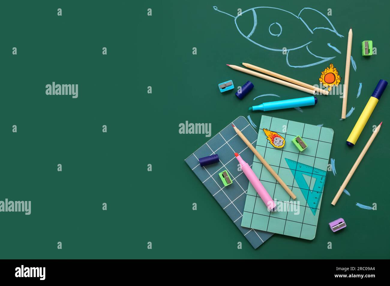 Creative composition with drawn rocket and different stationery on green chalkboard Stock Photo
