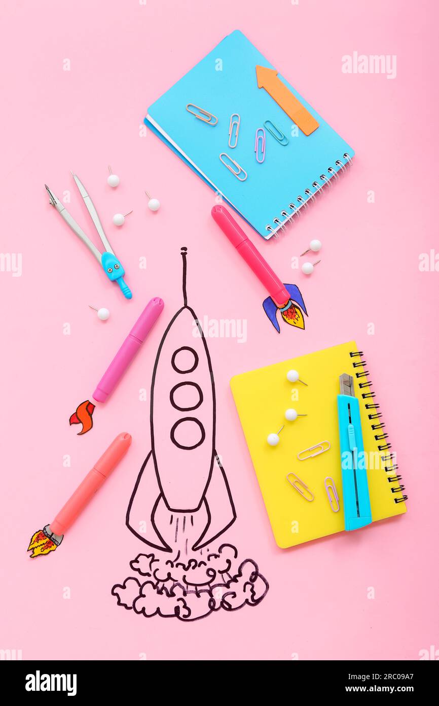 Creative composition with drawn rocket and different stationery on pink background Stock Photo