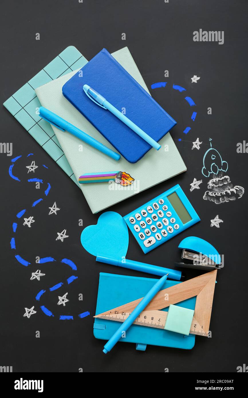 Creative composition with drawn rocket and different stationery on black chalkboard Stock Photo