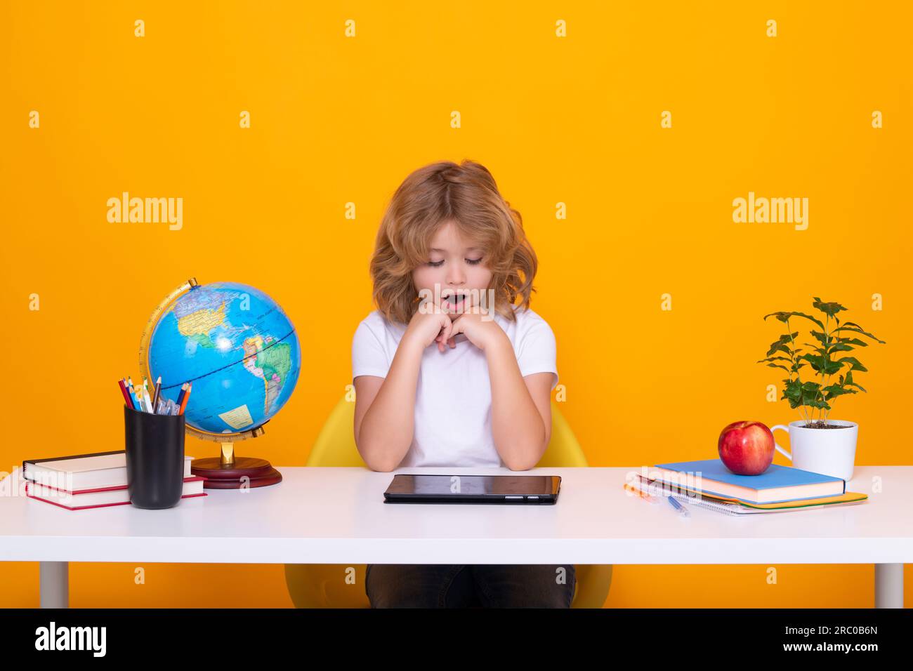 School child portrait isolated on yellow studio background. Kid boy ...