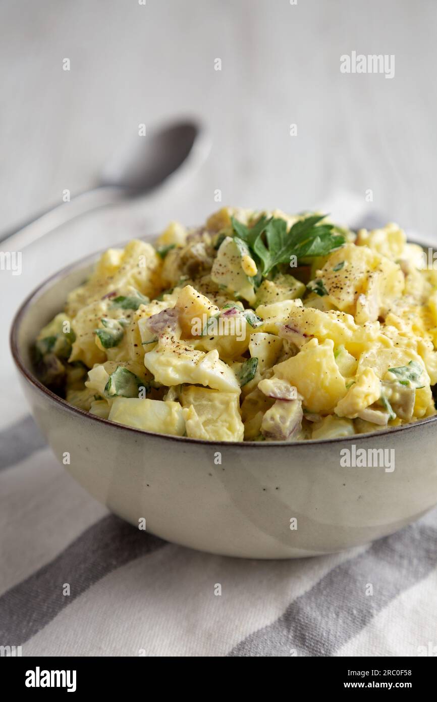 Homemade Potato Egg Salad with Pickles in a Bowl, side view Stock Photo