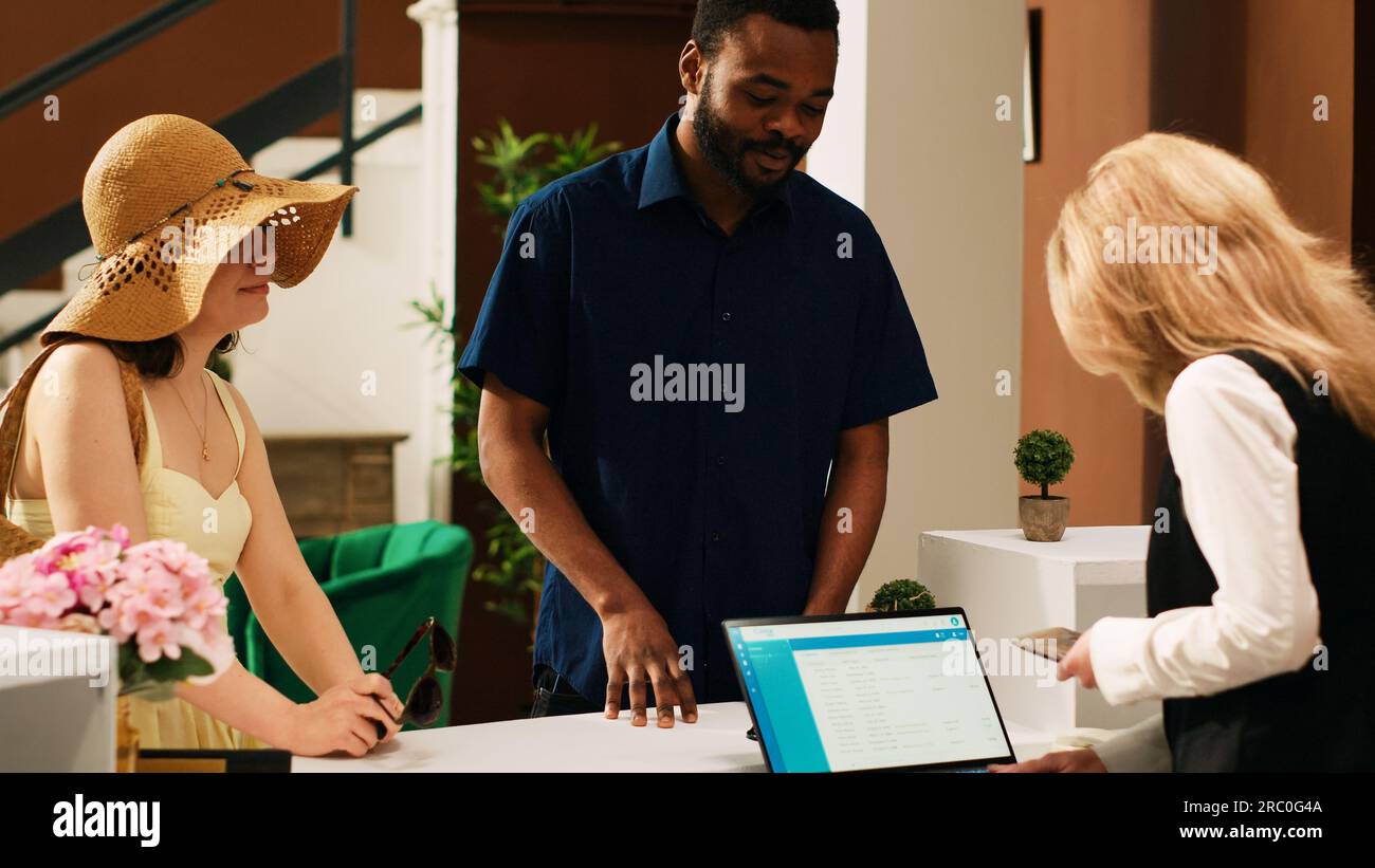 Front desk staff reviewing id papers to register tourists at tropical