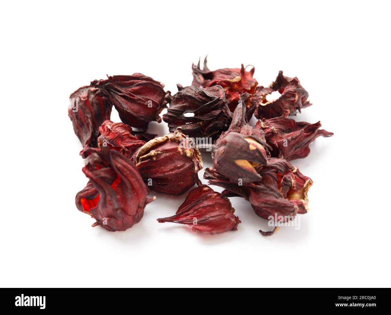 Hibiscus tea on a white background close-up. Dry flowers of red hibiscus on isolation. A handful of hibiscus for making tea. Stock Photo