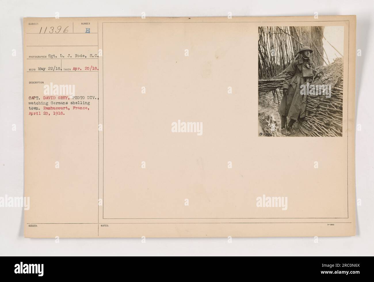 Captain David Grey, from the Photographic Division, observes German artillery bombardment of a town in Rambucourt, France on April 20, 1918. Photograph taken by Sgt. L. J. Rode. Captioned as Subject 11396, and dated May 22, 1918. Source: Photographs of American Military Activities during World War One. Stock Photo