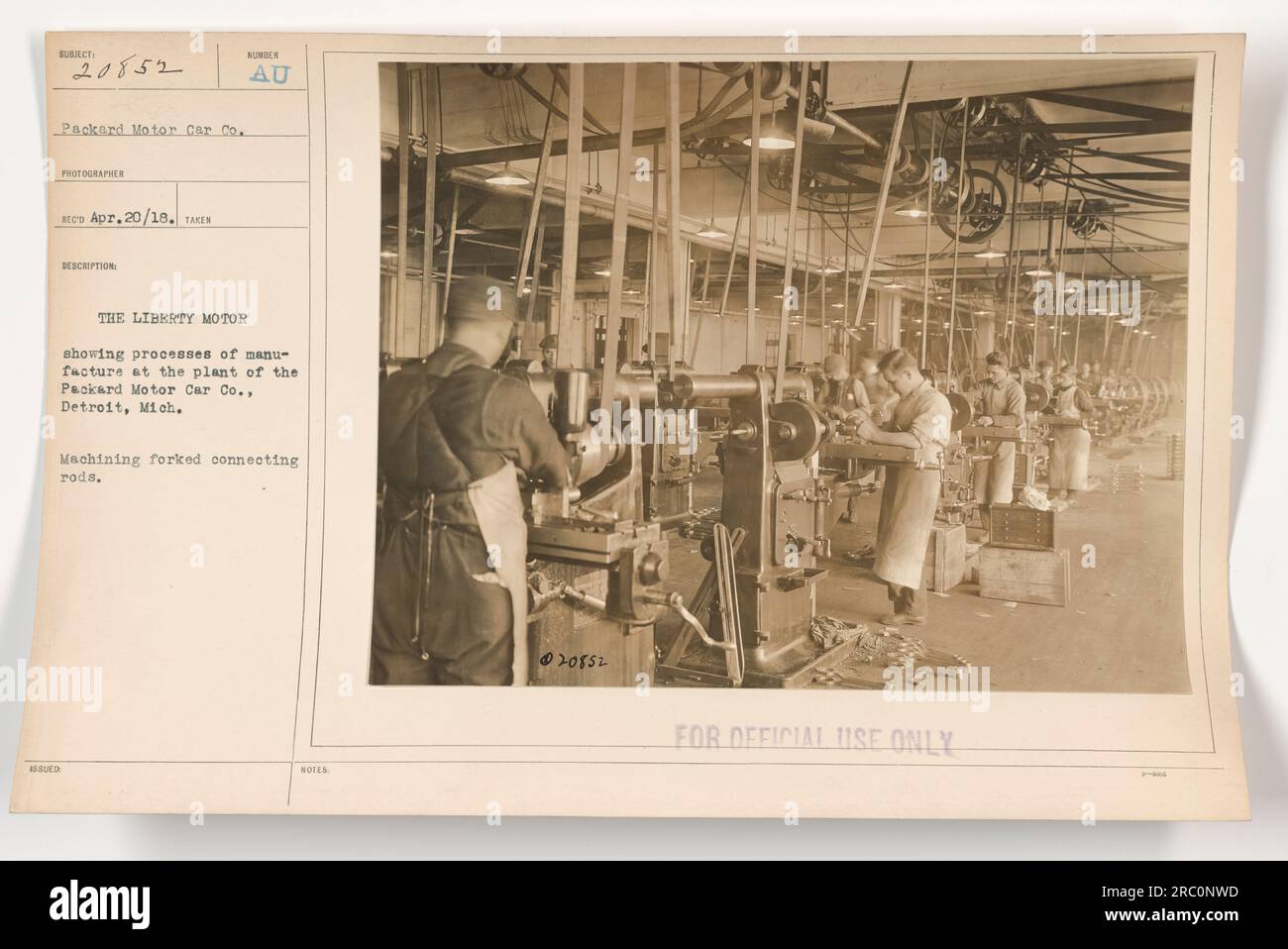 This photograph, labeled as 111-SC-20852, was taken on April 20, 1918, and is part of a series documenting American military activities during World War One. The image shows the manufacturing process at the Packard Motor Car Co. in Detroit, Michigan, specifically highlighting the machining of forked connecting rods for the Liberty Motor. This information is marked as 'For Official Use Only.' Stock Photo