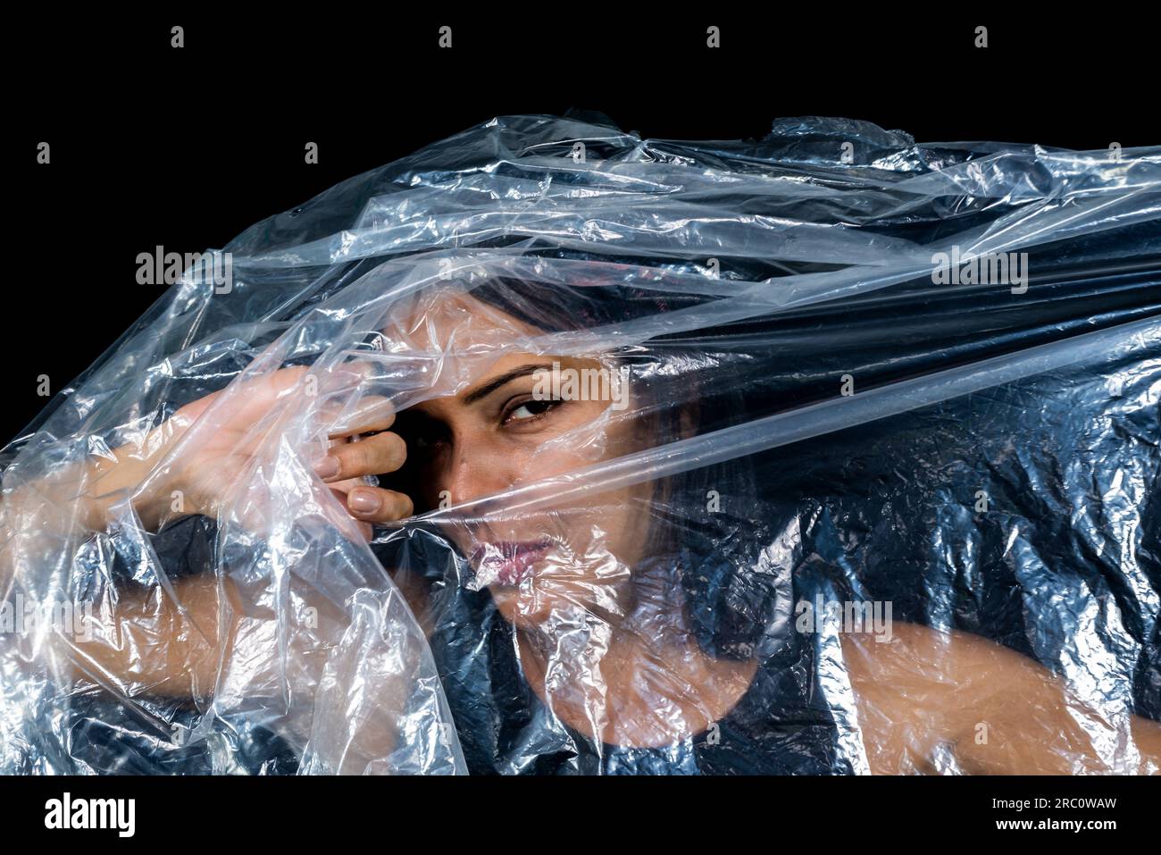 A woman with a plastic bag over her head looking through a hole