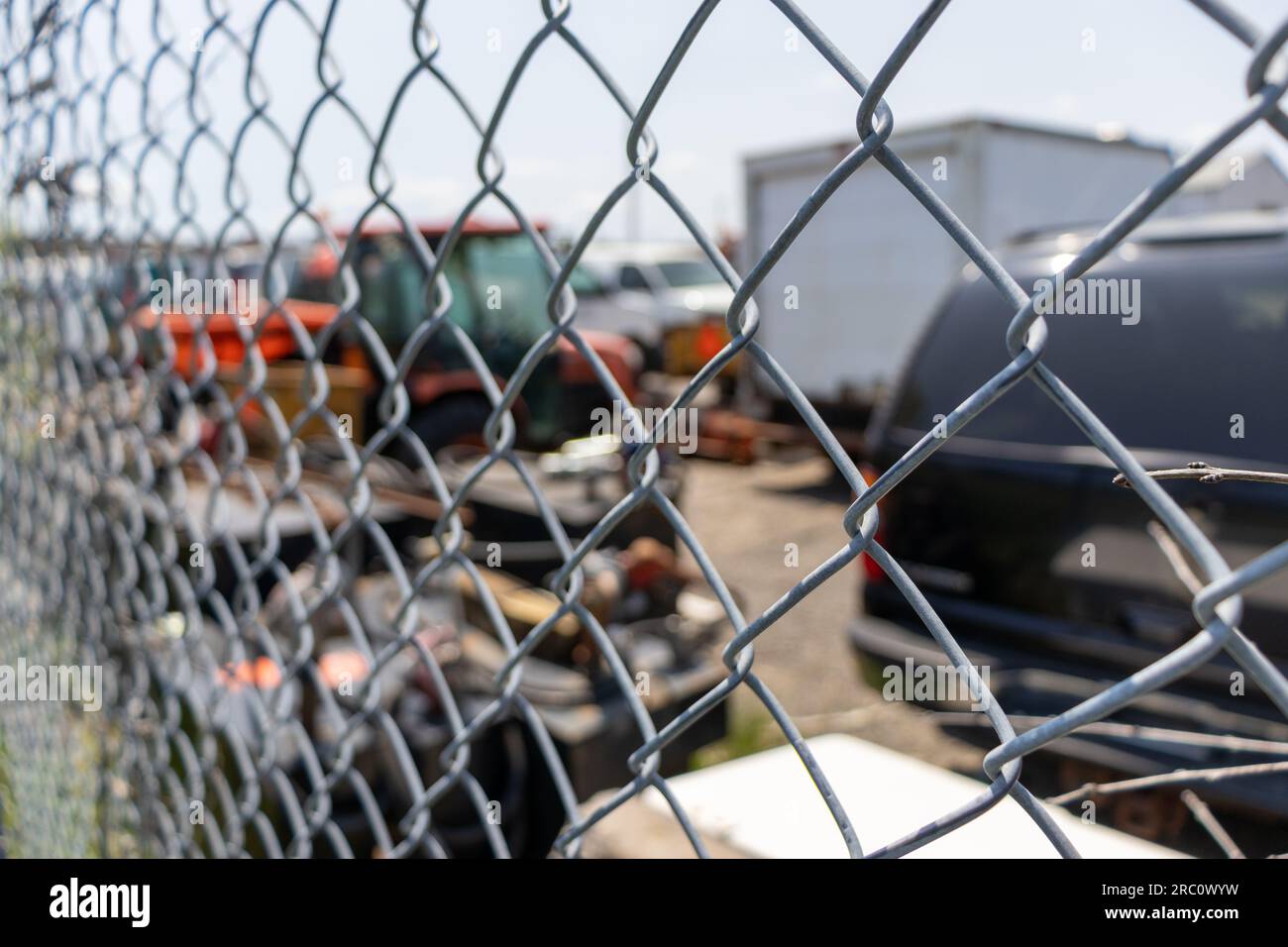 Side view of metal fence with vehicles behind - blurred background. Taken in Toronto, Canada. Stock Photo
