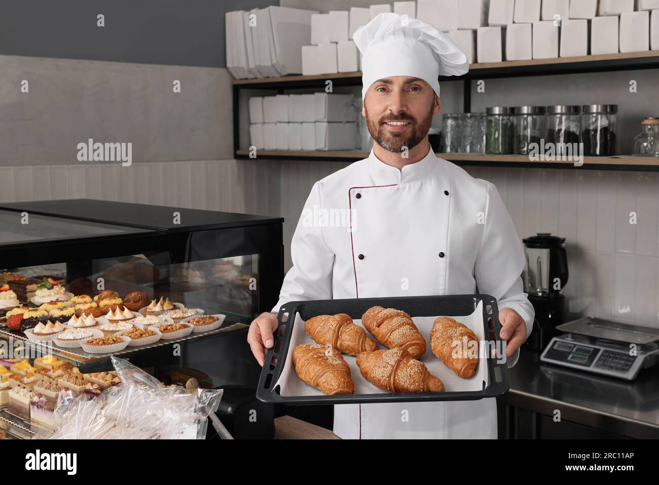 Professional baker with freshly baked croissants in store Stock Photo ...