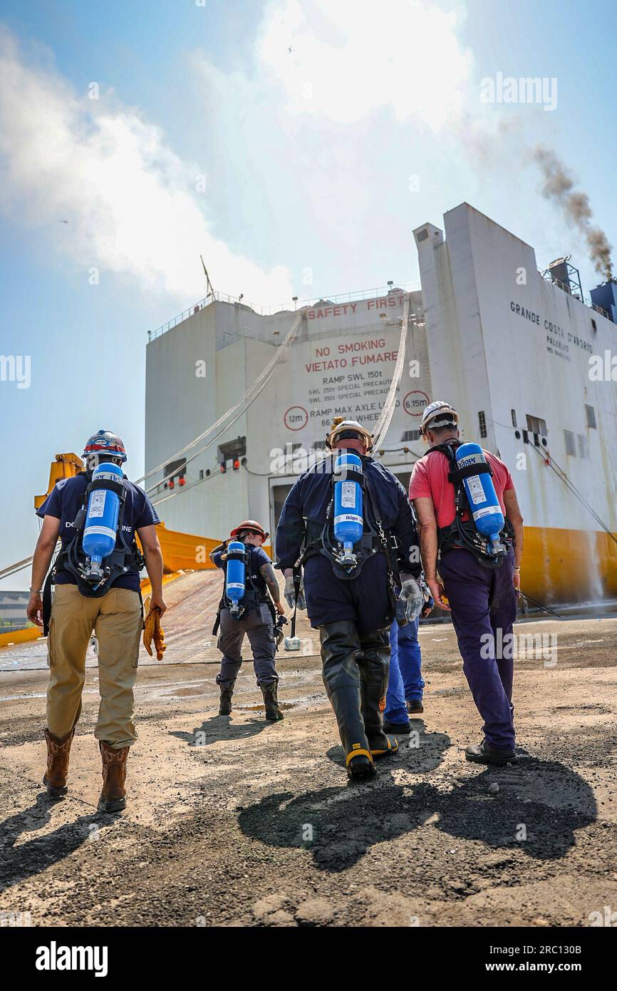 Salvage and marine firefighters from DONJON SMIT respond to a fire on the motor vessel Grande Costa D’Avorio in Port Newark, New Jersey, July 6, 2023. Marine fire fighting specialists are actively conducting fire suppression both from the pier and on the water. (U.S. Coast Guard photo by Dan Henry) Stock Photo