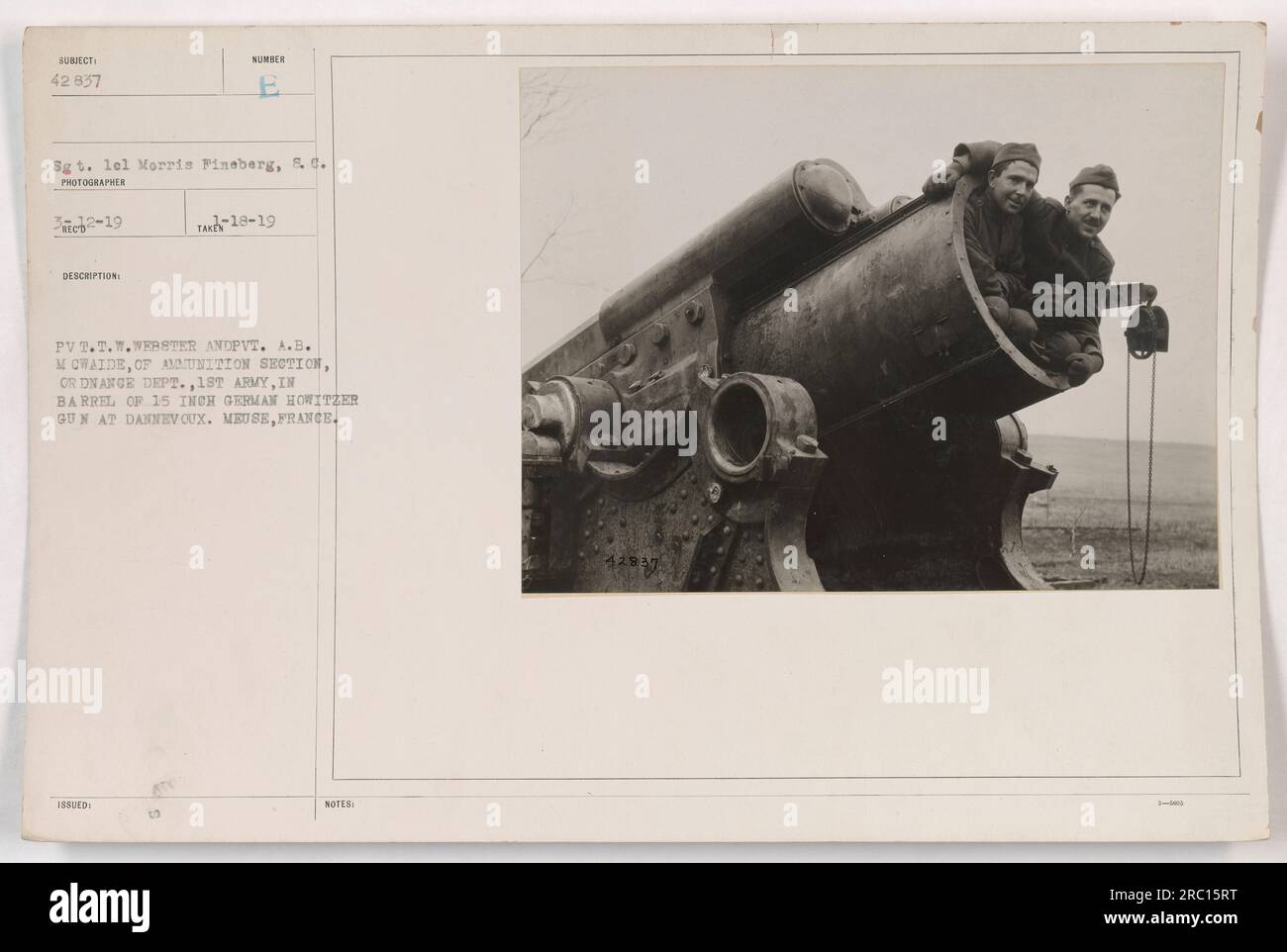 Sergeant Lel Morris Pineberg and Private T.T. Webster and Private A.B. McWaide from the ammunition section of the Ordnance Department, 18th Army, are pictured inside the barrel of a 15-inch German howitzer gun at Dannevoux, Meuse, France. Stock Photo