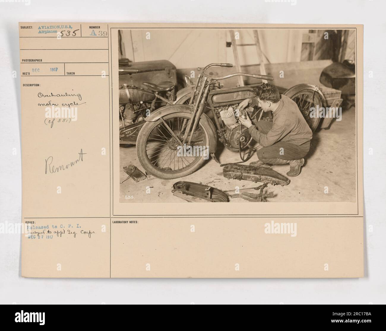 This photograph, numbered 111-SC-535, depicts the use of motorcycles for transportation between planes and photographic developers during World War One. The image was taken in 1917 as part of the U.S.A Airplanes 535 series. It shows a motorcycle being repaired (ef 551) for this purpose. The photograph was released to the C.P.I. (Central News Photo Service) on December 27, 1917. Stock Photo