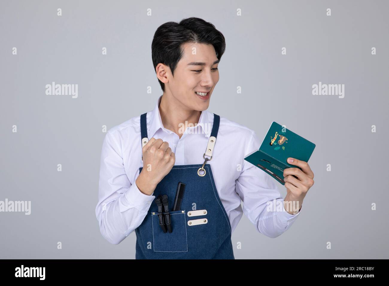 millennials and gen z, korean asian young man delighted whlie looking at his bankbook Stock Photo