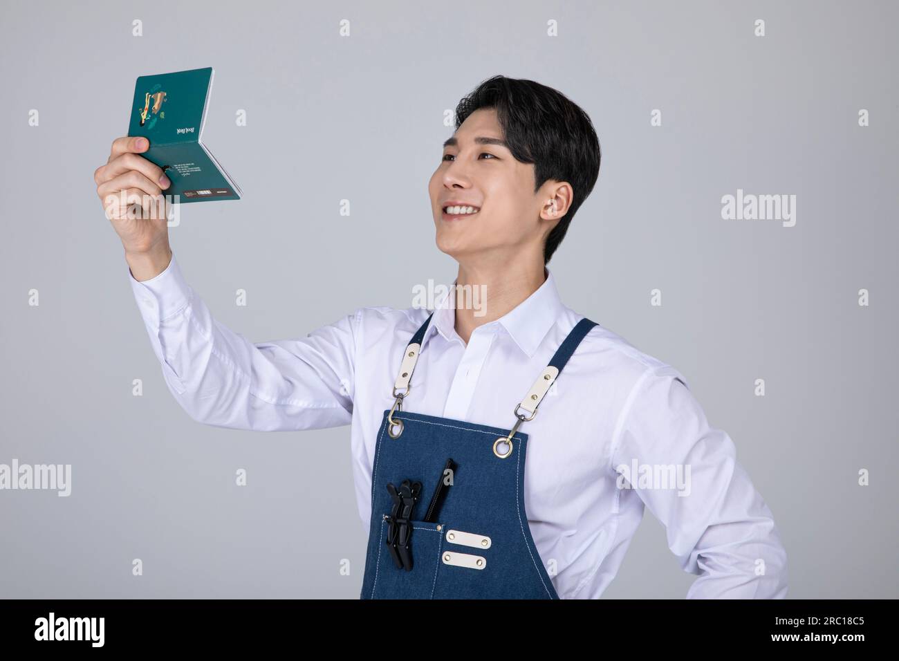 millennials and gen z, korean asian young man delighted whlie looking at his bankbook Stock Photo