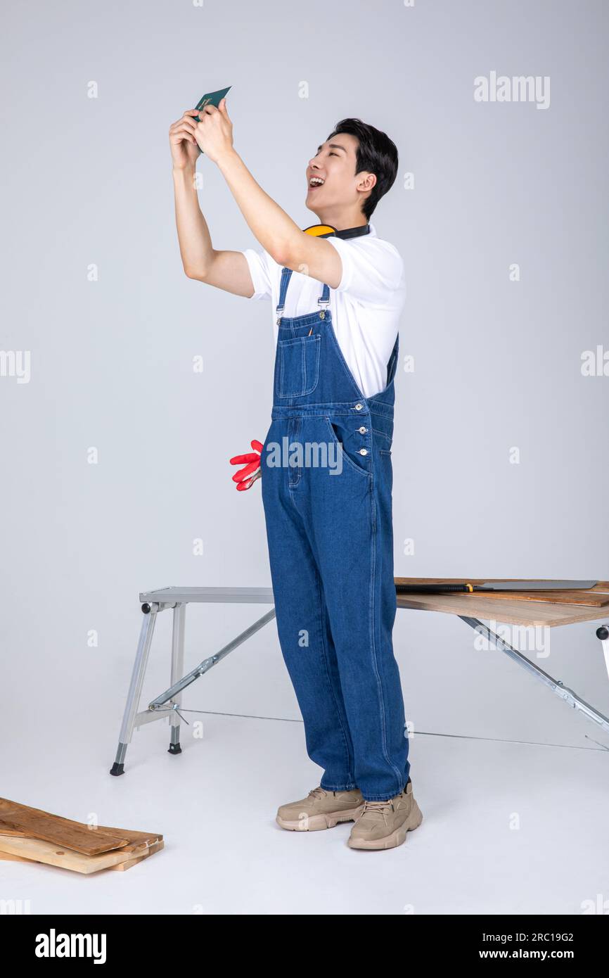 millennials and gen z, korean asian young man carpenter holding a bankbook Stock Photo