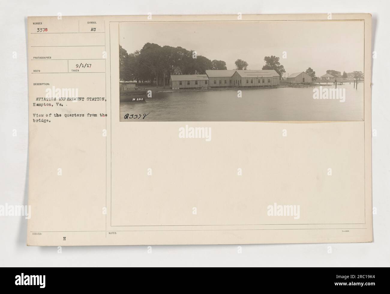 Image of the quarters at the Aviation Experiment Station in Hampton, Virginia. The photo was taken on September 1, 1917. The view is from the bridge. The photo is labeled as SUMBE 3378, and the photographer's name is RECO. The photo is specifically designated as an 'issued' image, and the 'desorption' and 'synol' notations are unclear. Stock Photo