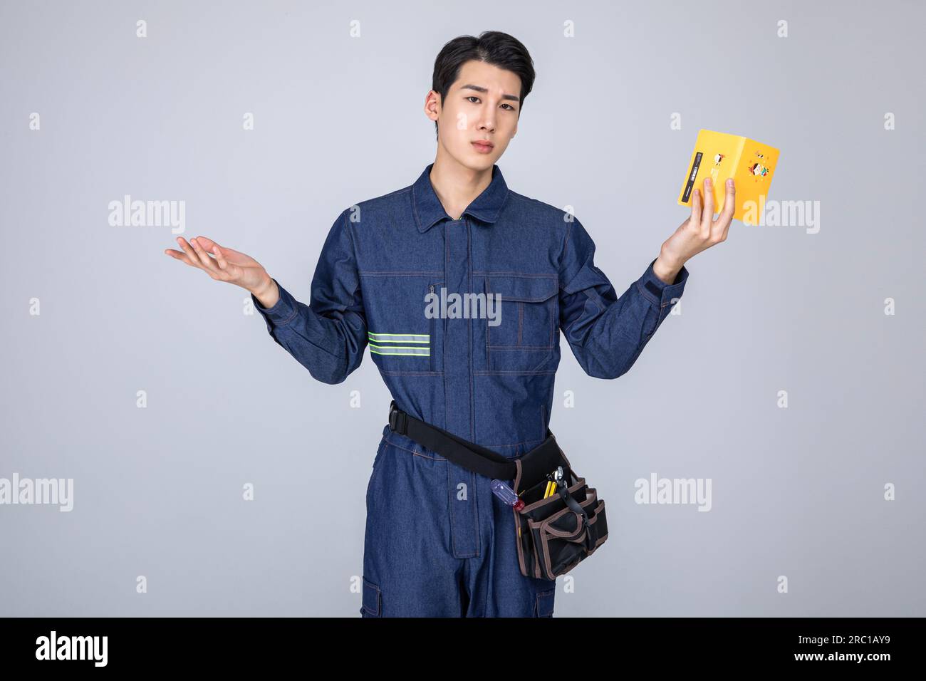 millennials and gen z, korean asian young man, site staff grimacing with a bankbook Stock Photo