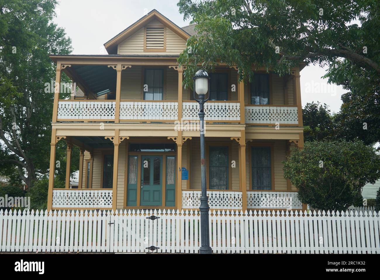 A historic French Creole style house with a wrap-around porch and a white picket fence in Pensacola, Florida. Stock Photo