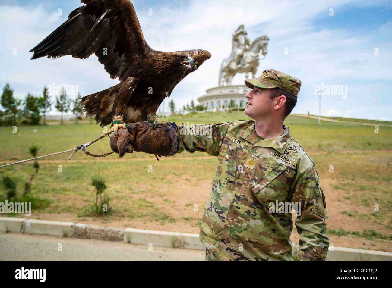 June 23, 2023 - Tsonjin Boldog, Ulaanbaatar, Mongolia - Alaska Army National Guard State Partnership Program coordinator Maj. Levi Vail poses with an eagle on his arm as he stands in front of The Chinggis Khaan Equestrian Statue at the Chinggis Khaan Statue Complex on the bank of the Tuul River at Tsonjin Boldog east of the Mongolian capital Ulaanbaatar, June 23, 2023. Alaska and Mongolia were partnered in 2003 under the National Guard's State Partnership Program. More than 1,500 Alaska Air and Army Guardsmen have traveled to Mongolia for training and exercises in support of Mongolia's peaceke Stock Photo