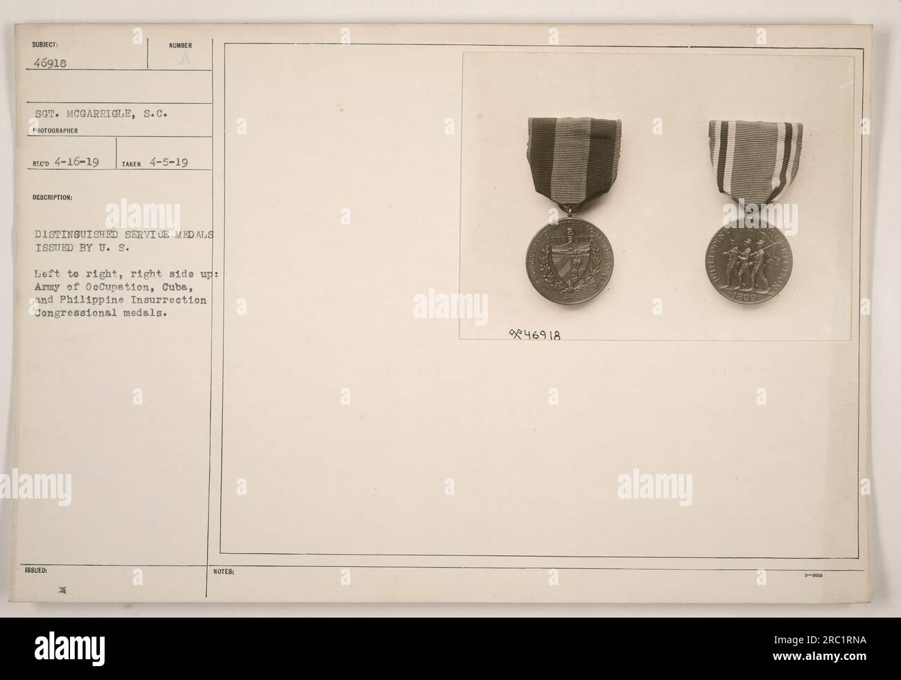 Distinguished Service Medals issued by the U.S. are displayed in the photograph. From left to right, right side up, the medals are: Army of Occupation, Cuba, and Philippine Insurrection congressional medals. The subject of the photograph is Sergeant McGarrigle, who was the recipient of the medals. The photo was taken on April 5, 1919. There are a total of 18 medals visible in the image. Stock Photo