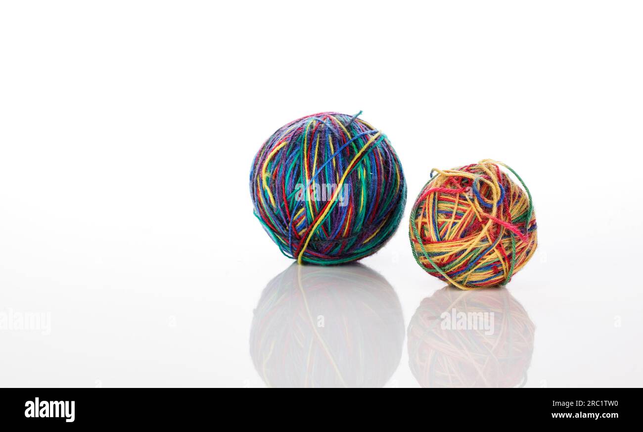 Two multicoloured wool balls on a white background with soft reflection Stock Photo