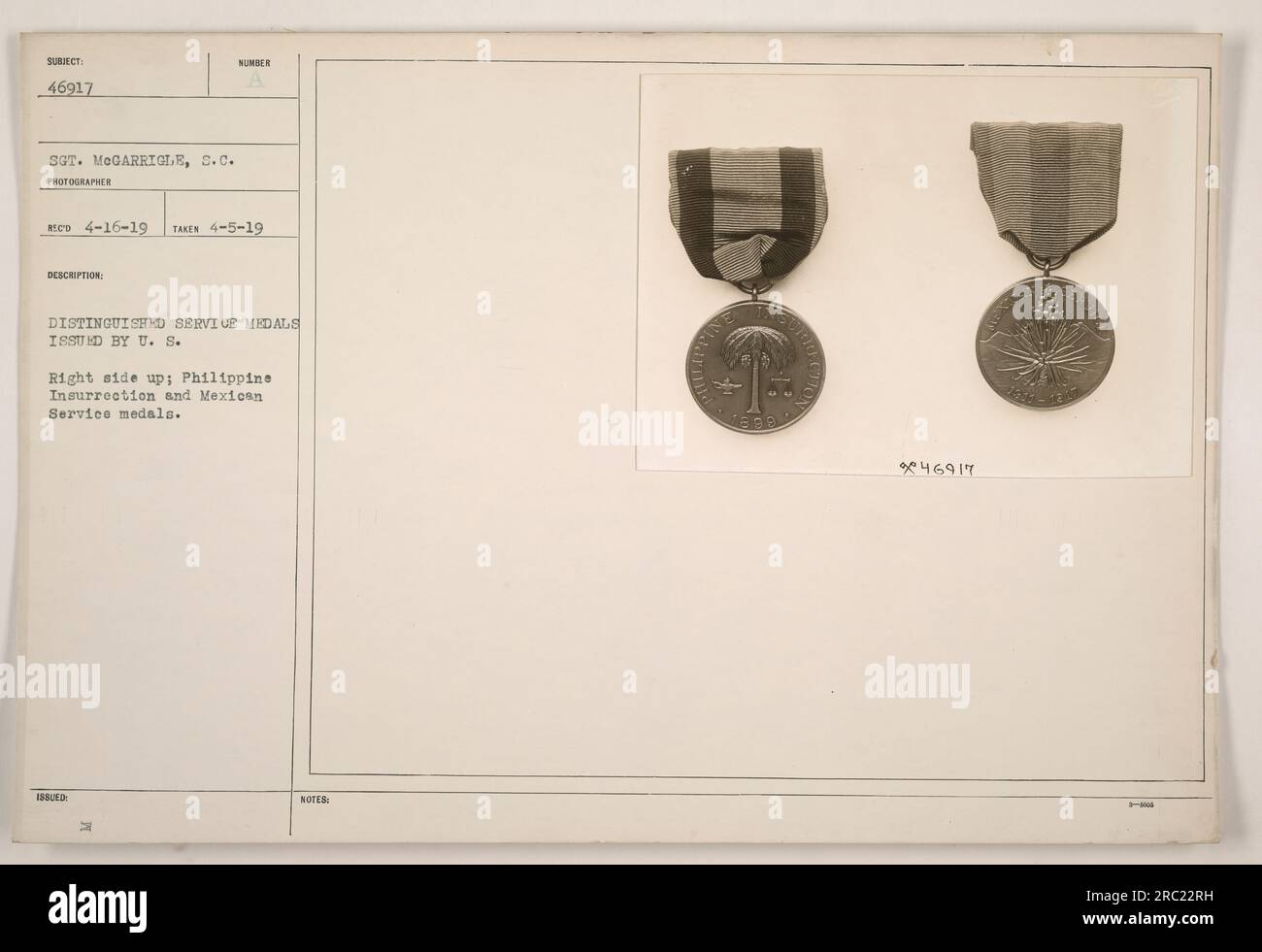 This photograph shows the Distinguished Service Medals issued by the U.S. military, specifically the Philippine Insurrection and Mexican Service medals. The medals are displayed in the image, with the Philippine Insurrection medal seen on the right side and the Mexican Service medal on the left side, as displayed right side up according to military protocol. The photograph was taken on April 5, 1919 and received by the photographer on April 16, 1919. The photographed individual is identified as Sergeant McGarrigle with the serial number 46917. Stock Photo